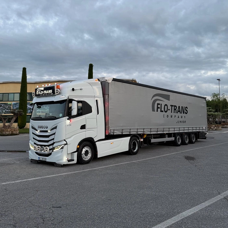 Cap tractor Iveco modern si semi-remorca fotografiate intr-o parcare la un client
